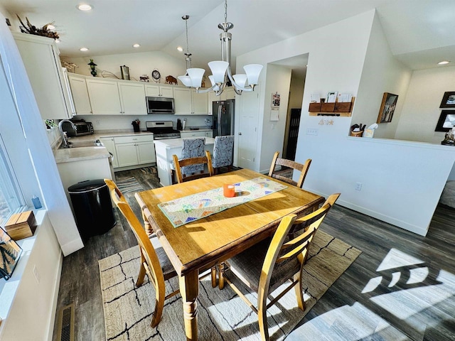 dining space featuring dark hardwood / wood-style flooring, sink, vaulted ceiling, and a chandelier