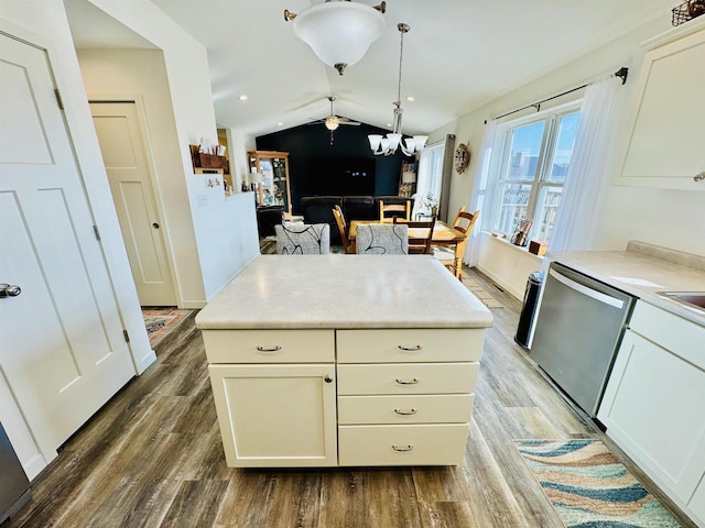 kitchen featuring pendant lighting, lofted ceiling, dishwasher, and hardwood / wood-style floors