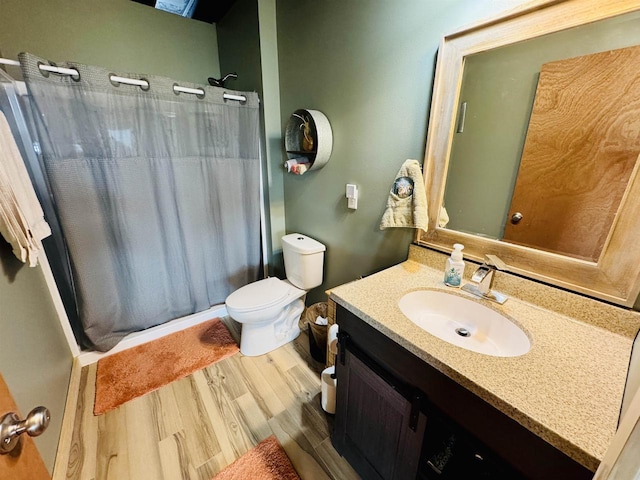 bathroom featuring wood-type flooring, toilet, and vanity