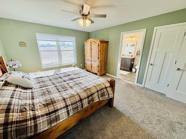 bedroom featuring ceiling fan, light carpet, and ensuite bath