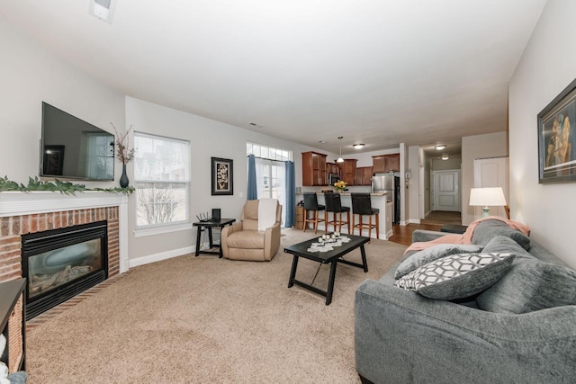 living room featuring light colored carpet and a brick fireplace