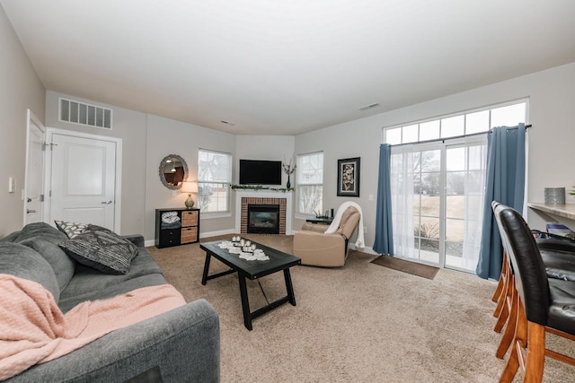 carpeted living room featuring a fireplace and plenty of natural light