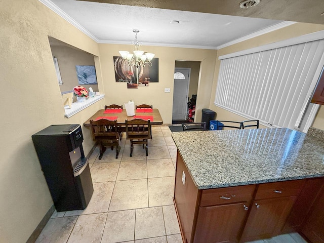 kitchen with ornamental molding, light stone countertops, light tile patterned floors, and an inviting chandelier