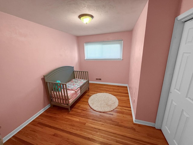 bedroom featuring wood-type flooring and a textured ceiling