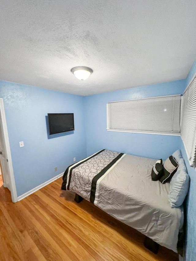 bedroom featuring wood-type flooring and a textured ceiling