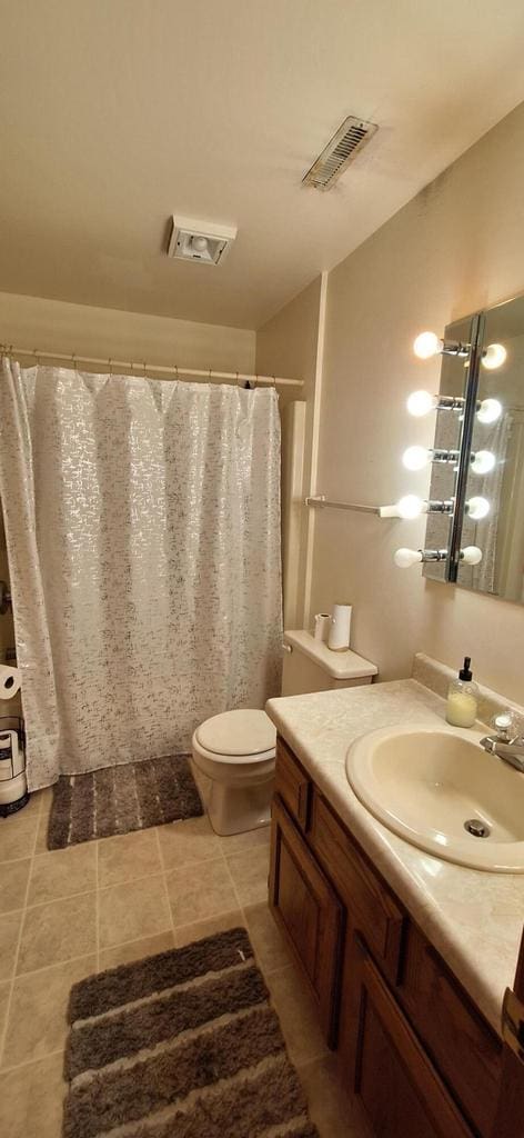 bathroom featuring tile patterned flooring, vanity, and toilet