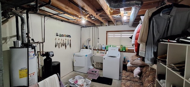 basement with sink, water heater, and washing machine and clothes dryer