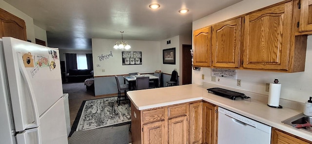 kitchen with decorative light fixtures, a notable chandelier, white appliances, and kitchen peninsula