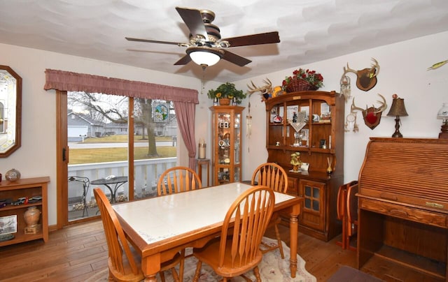 dining space with wood-type flooring and ceiling fan