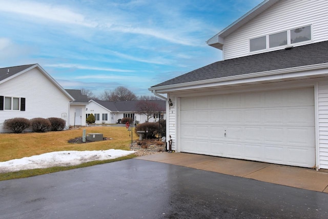 exterior space featuring a garage and a lawn