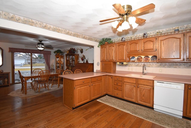 kitchen featuring sink, dark hardwood / wood-style floors, white dishwasher, kitchen peninsula, and ceiling fan