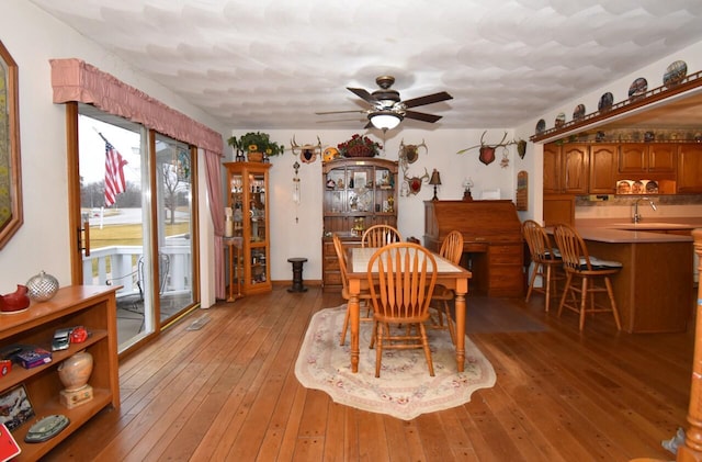 dining space featuring sink, ceiling fan, and light hardwood / wood-style flooring