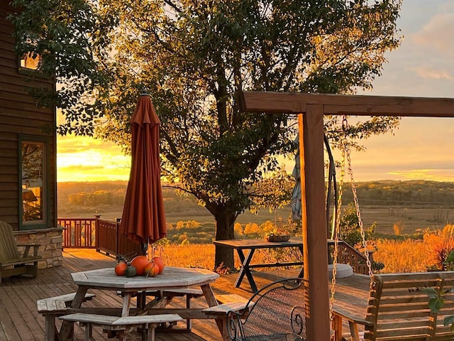 deck at dusk featuring outdoor dining area