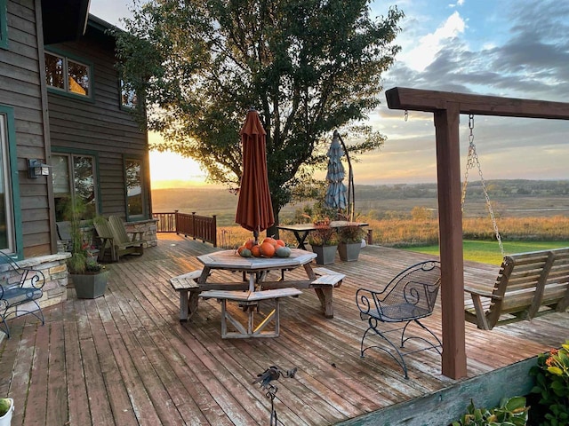 deck at dusk featuring outdoor dining space