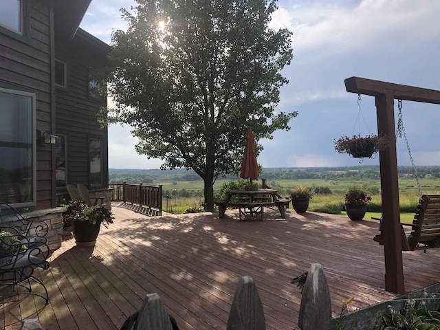 wooden deck with outdoor dining area and a rural view