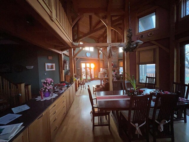 dining space featuring light wood finished floors and high vaulted ceiling