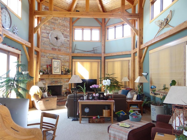 carpeted living area with a stone fireplace, wooden ceiling, beam ceiling, and a wealth of natural light