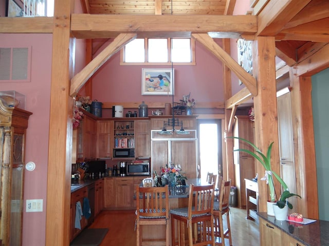 kitchen featuring decorative light fixtures, stainless steel microwave, high vaulted ceiling, beamed ceiling, and dishwashing machine