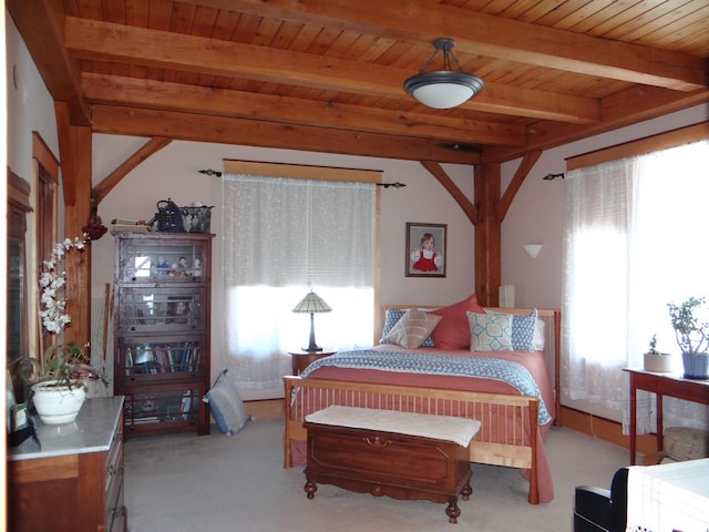 bedroom with light colored carpet, wood ceiling, multiple windows, and beamed ceiling