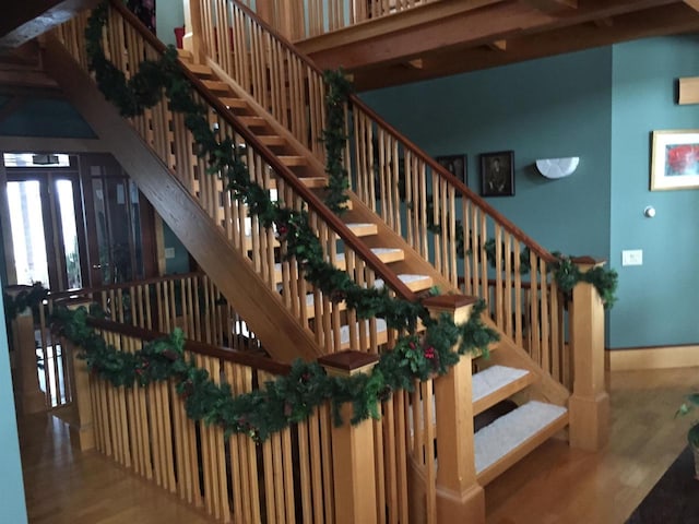 stairs featuring french doors, wood finished floors, and baseboards