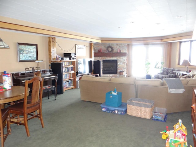 living room featuring dark carpet and a stone fireplace