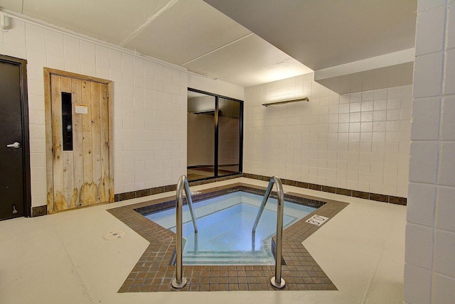 view of swimming pool with an indoor in ground hot tub