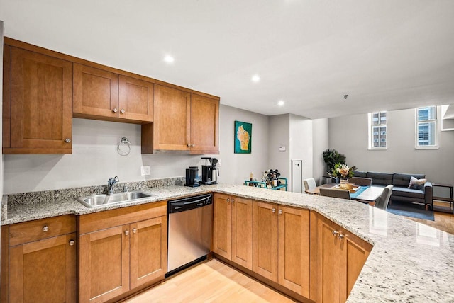 kitchen with light stone counters, sink, stainless steel dishwasher, and kitchen peninsula