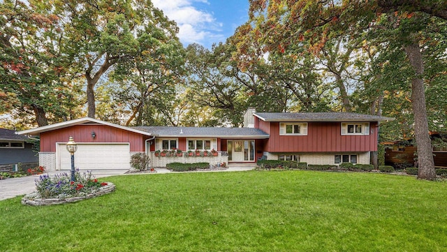 split level home with a garage and a front lawn