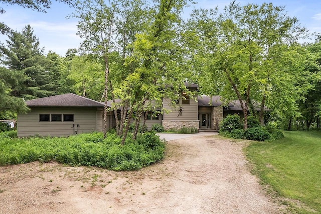 E4725 Riverside Dr, Spring Green, WI 53588 - view of front of house with driveway, stone siding, and a front lawn