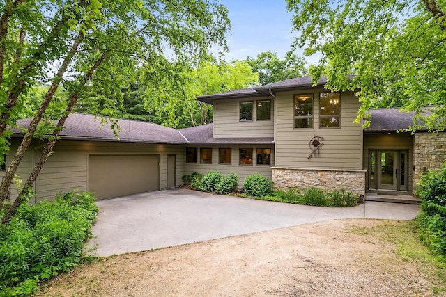 E4725 Riverside Dr, Spring Green, WI 53588 - view of front of home featuring concrete driveway, an attached garage, stone siding, and a shingled roof