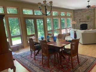 E4725 Riverside Dr, Spring Green, WI 53588 - dining room featuring a chandelier, light wood-style floors, ceiling fan, and a fireplace