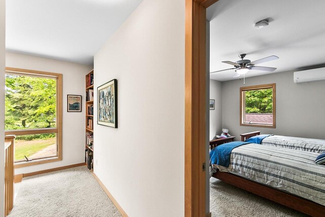 E4725 Riverside Dr, Spring Green, WI 53588 - bedroom featuring light carpet, multiple windows, a wall mounted AC, and baseboards