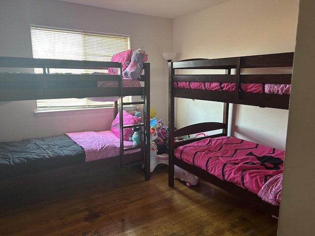 bedroom with dark hardwood / wood-style floors and multiple windows