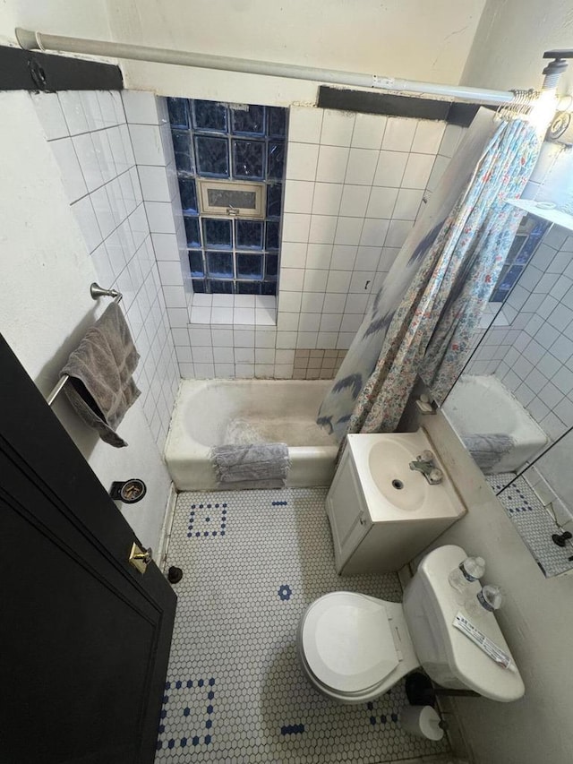 bathroom featuring tile patterned flooring, toilet, and shower / bath combo with shower curtain