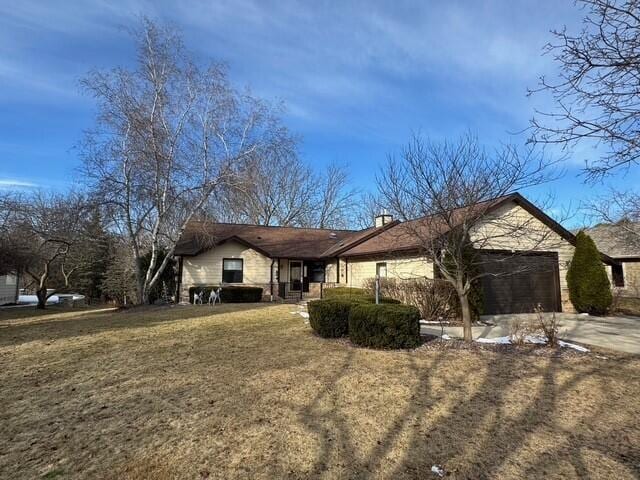 single story home featuring a garage and a front yard