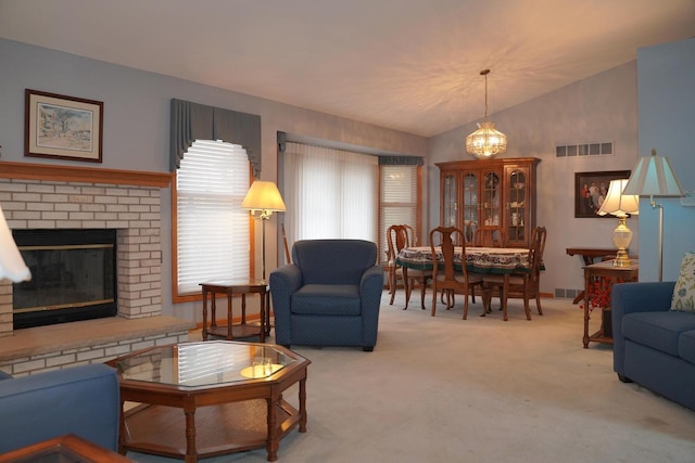 carpeted living room featuring vaulted ceiling and a fireplace