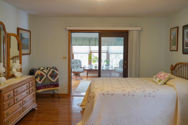 bedroom with hardwood / wood-style floors and access to exterior