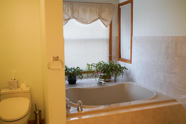 bathroom featuring tiled bath and a healthy amount of sunlight