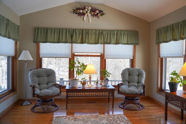 sitting room with vaulted ceiling and wood-type flooring