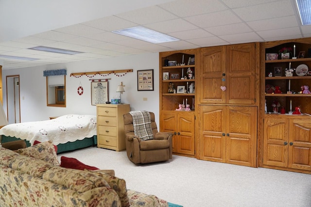 carpeted bedroom featuring a drop ceiling