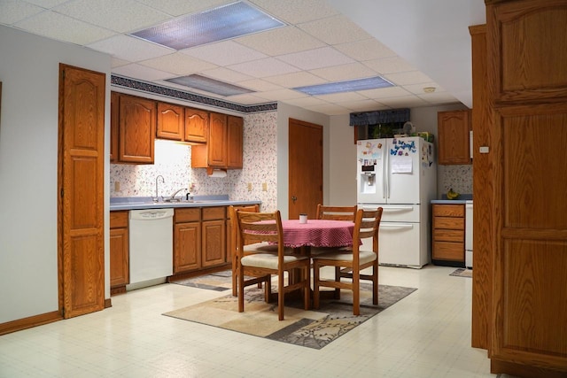 kitchen with white appliances and a paneled ceiling