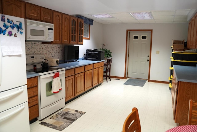 kitchen featuring white appliances and a paneled ceiling