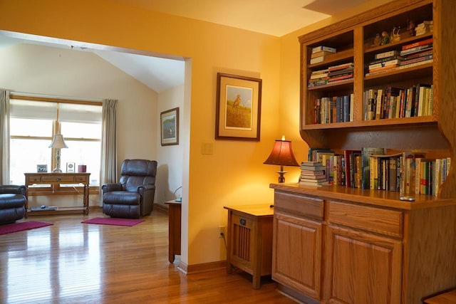 living area featuring vaulted ceiling and light wood-type flooring