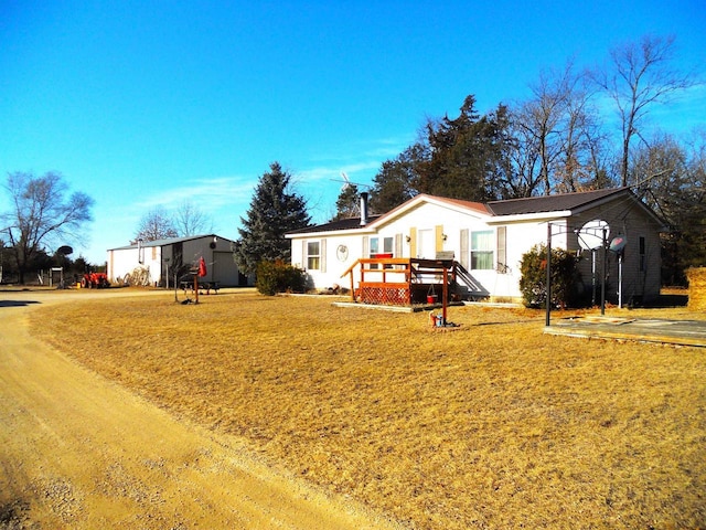 view of side of property with a deck and a lawn