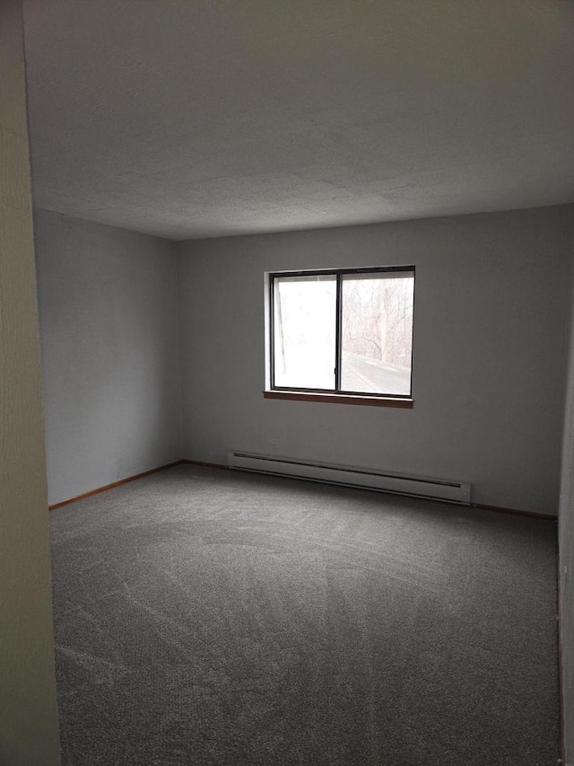 spare room featuring a baseboard radiator and carpet floors