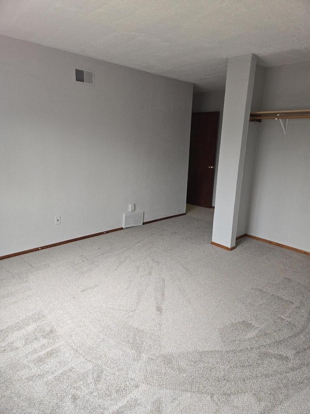 unfurnished bedroom featuring a closet, a textured ceiling, and carpet flooring