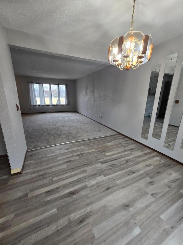 interior space with a chandelier, hardwood / wood-style floors, and a textured ceiling