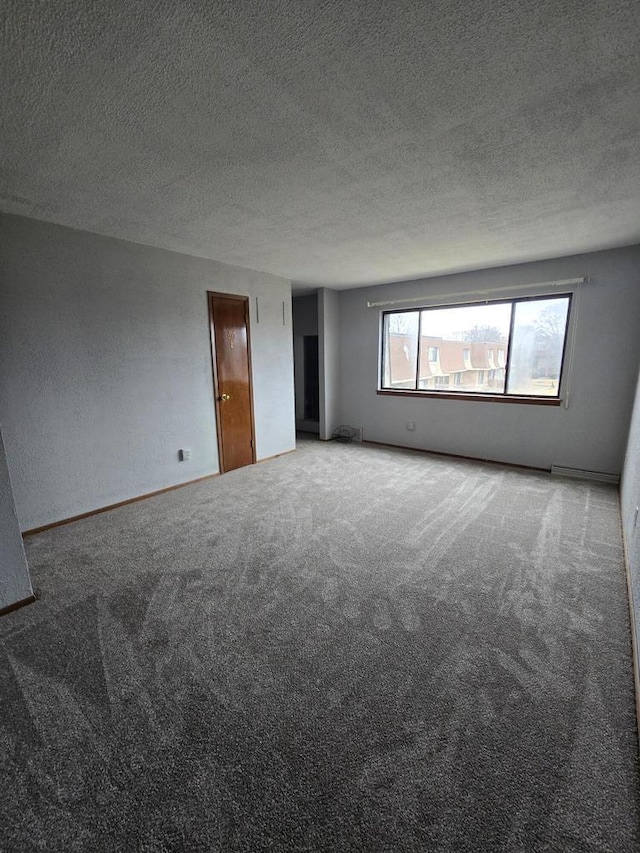 empty room with carpet flooring and a textured ceiling