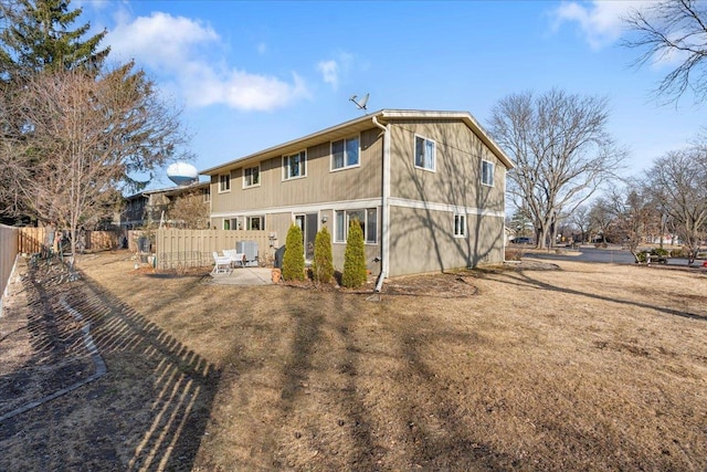 rear view of property with fence and a patio area