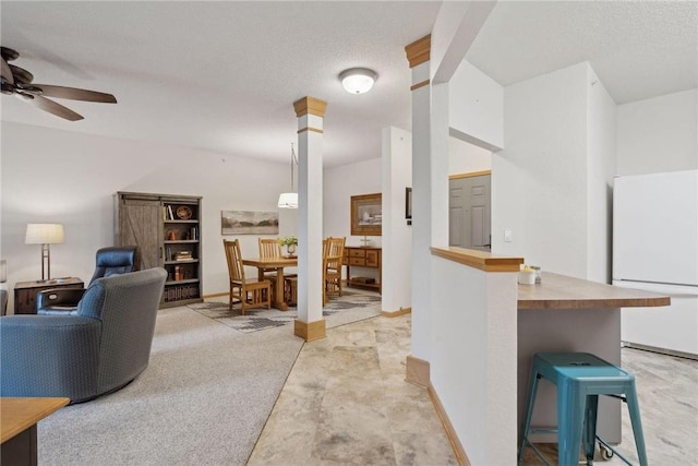 living room featuring ceiling fan and a textured ceiling